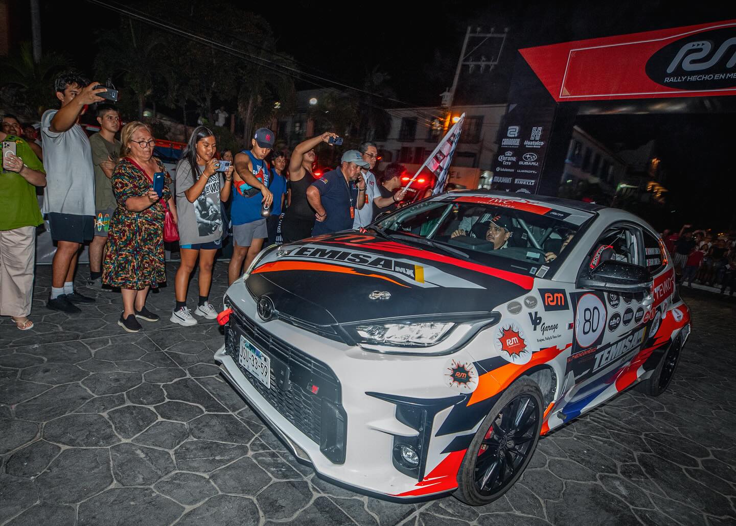 El GR Yaris de SNZ rodeado de público durante la salida del rally